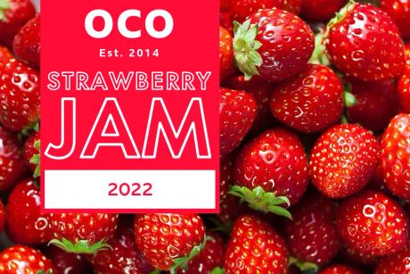 An image of red, juicy strawberries as the background, with a red box on the left side holding the content. OCO Est. 2014 sits at the top of the box, with Strawberry Jam 2022 sitting underneath.