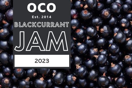 An image of blackcurrants as the background, with a charcoal grey box on the left side holding the content. OCO Est. 2014 sits at the top of the box, with Blackcurrant Jam 2022 sitting underneath.